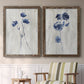 Set of two walnut barnwood framed canvas prints depicting two rustic monochrome botanical paintings featuring blue wildflower stems on weathered neutral paper above a sideboard in a cozy sitting room.