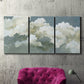 Three-panel canvas wall art featuring abstract evening landscape with depth, displayed in a living room above a suede accent chair.