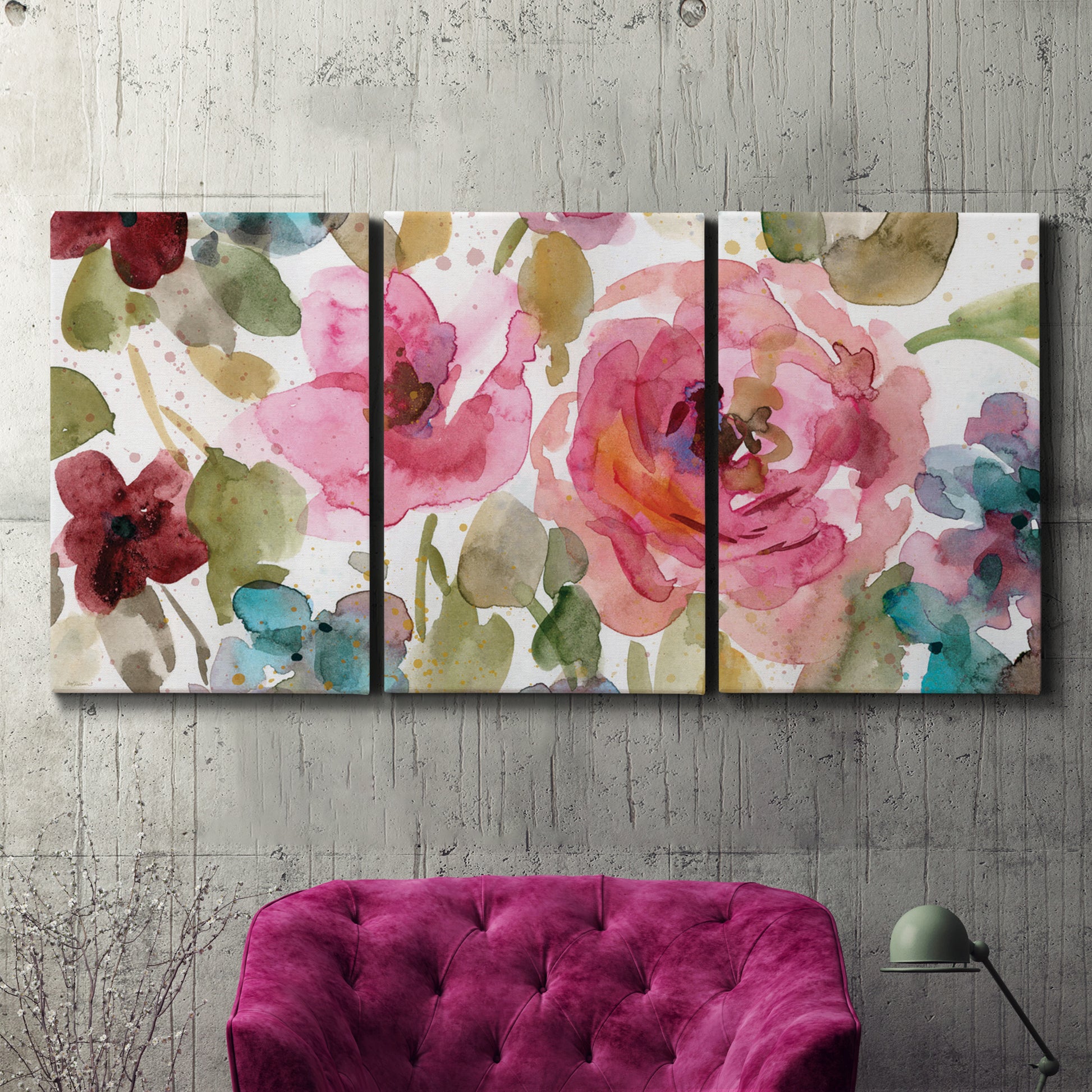 Three-panel canvas wall art featuring colorful floral watercolor composition, displayed in a living room above a suede accent chair.