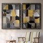 Set of two black barnwood framed canvas prints depicting two structured modern abstracts featuring interlocking black gray cream and gold geometric sections above a sideboard in a cozy sitting room.