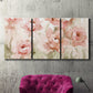 Three-panel canvas wall art featuring spring floral blossoms in bloom, displayed in a living room above a suede accent chair.