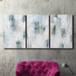 Three-panel canvas wall art featuring industrial textured abstract hatch patterns, displayed in a living room above a suede accent chair.