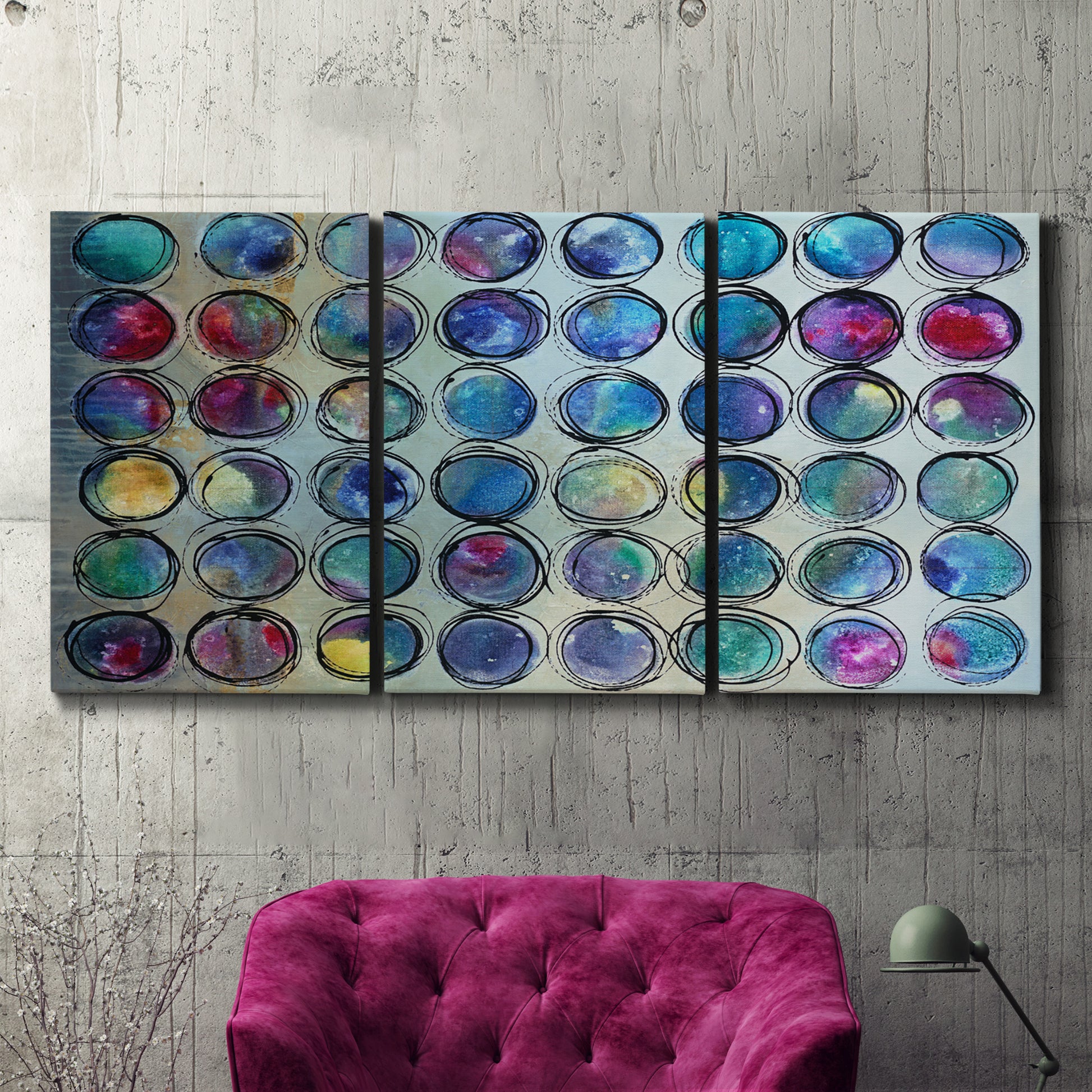 Three-panel canvas wall art featuring contrasting geometric abstract variations, displayed in a living room above a suede accent chair.