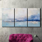 Three-panel canvas wall art featuring abstract bay with rhythmic forms, displayed in a living room above a suede accent chair.