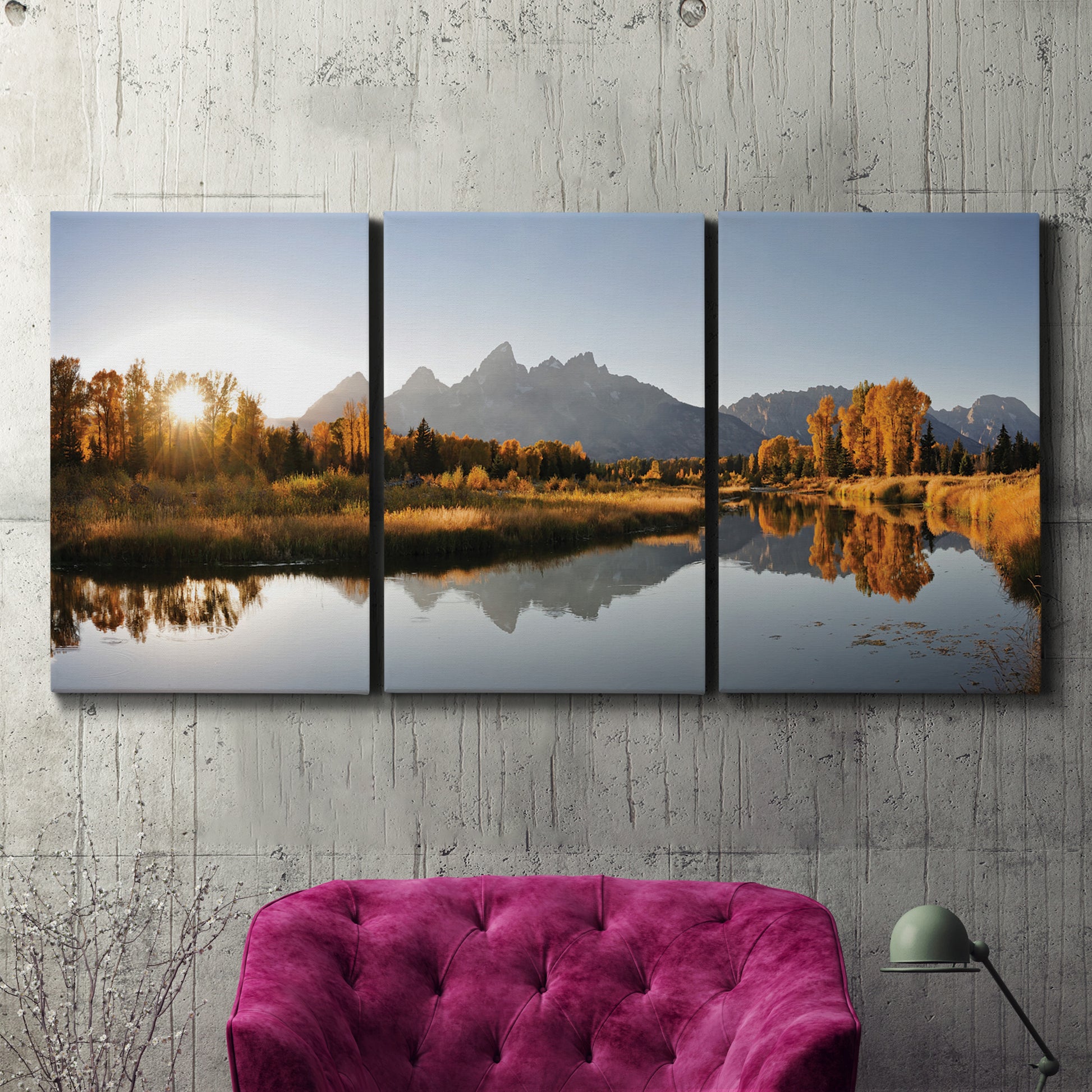 Three-panel canvas wall art featuring river canyon landscape photograph, displayed in a living room above a suede accent chair.