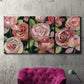 Three-panel canvas wall art featuring bold red floral abstraction, displayed in a living room above a suede accent chair.