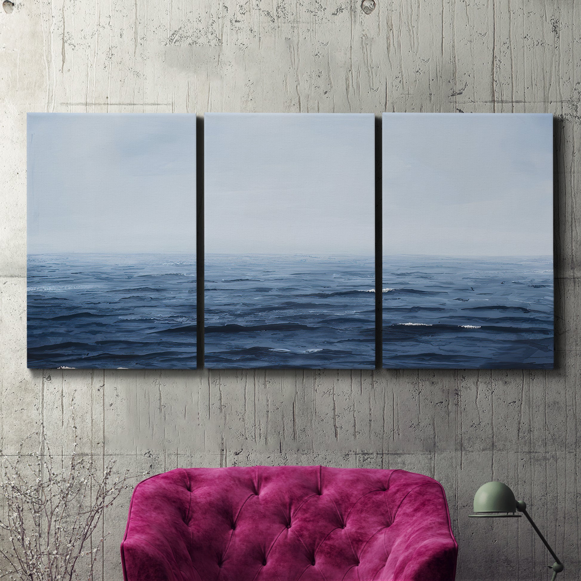 Three-panel canvas wall art featuring grayscale seascape with horizon, displayed in a living room above a suede accent chair.