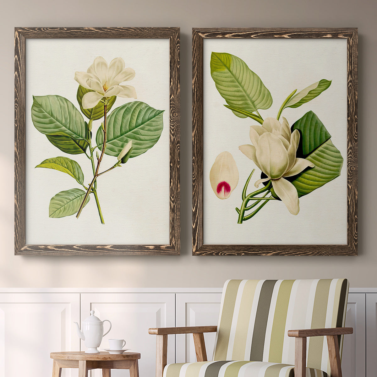 Set of two walnut barnwood framed canvas prints depicting two traditional botanical paintings featuring white magnolia blossoms and glossy green leaves above a sideboard in a cozy sitting room.