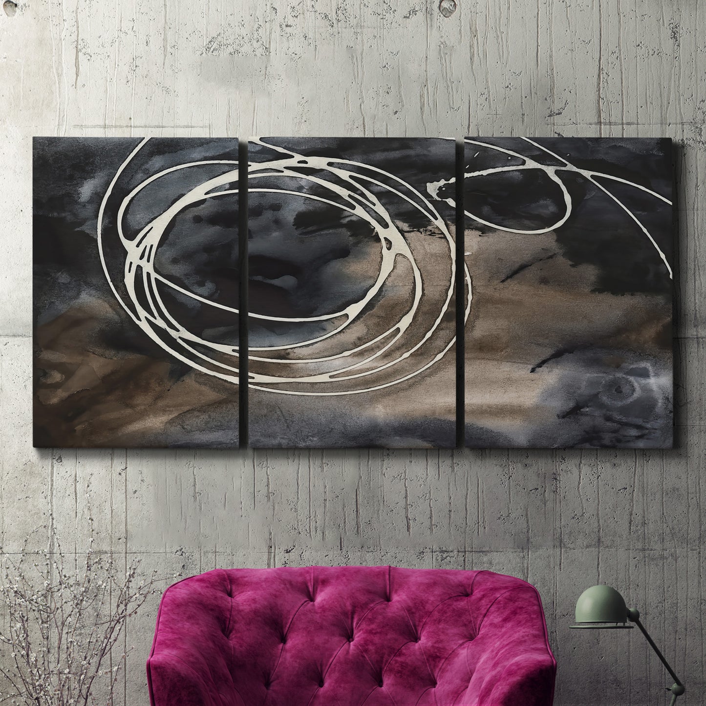 Three-panel canvas wall art featuring dark swirling abstract motion, displayed in a living room above a suede accent chair.