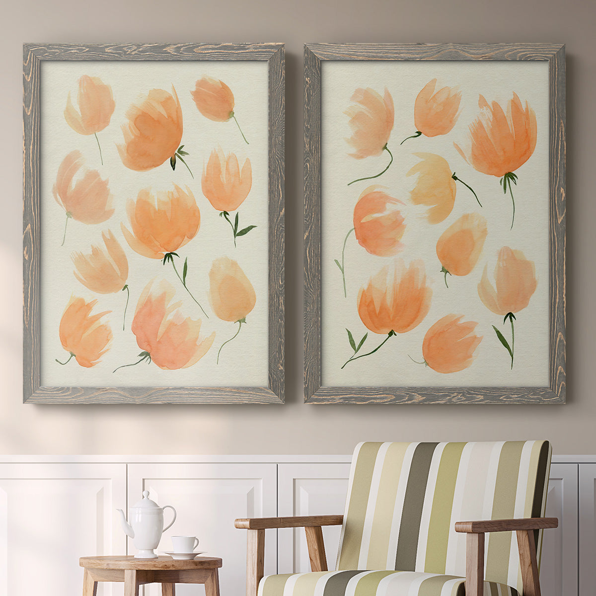 Set of two gray barnwood framed canvas prints depicting two airy watercolor floral paintings featuring loose peach-orange tulip-like blossoms above a sideboard in a cozy sitting room.