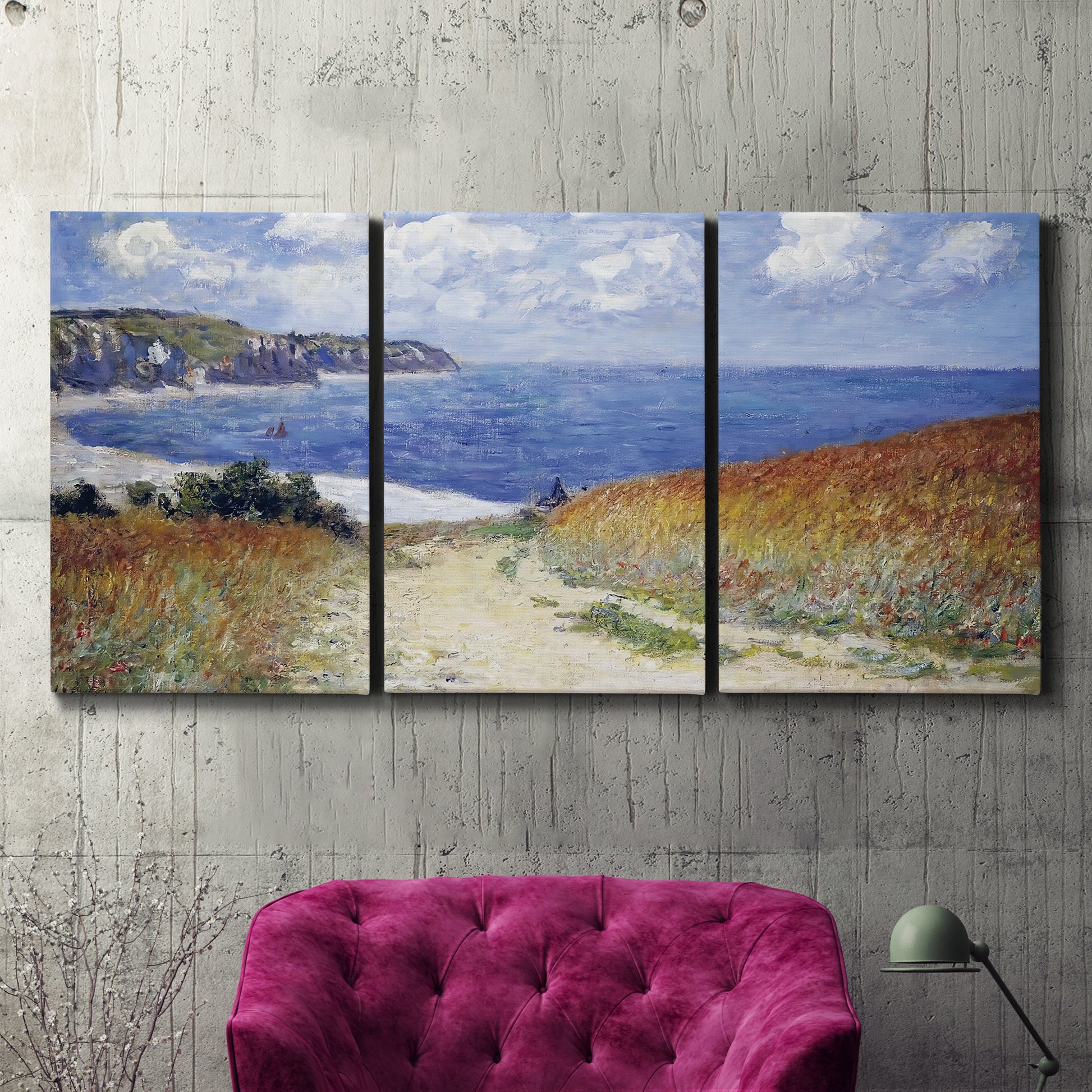 Three-panel canvas wall art featuring coastal path leading to sea, displayed in a living room above a suede accent chair.
