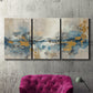 Three-panel canvas wall art featuring abstract soft morning light, displayed in a living room above a suede accent chair.