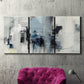 Three-panel canvas wall art featuring cool abstract winter color wash, displayed in a living room above a suede accent chair.