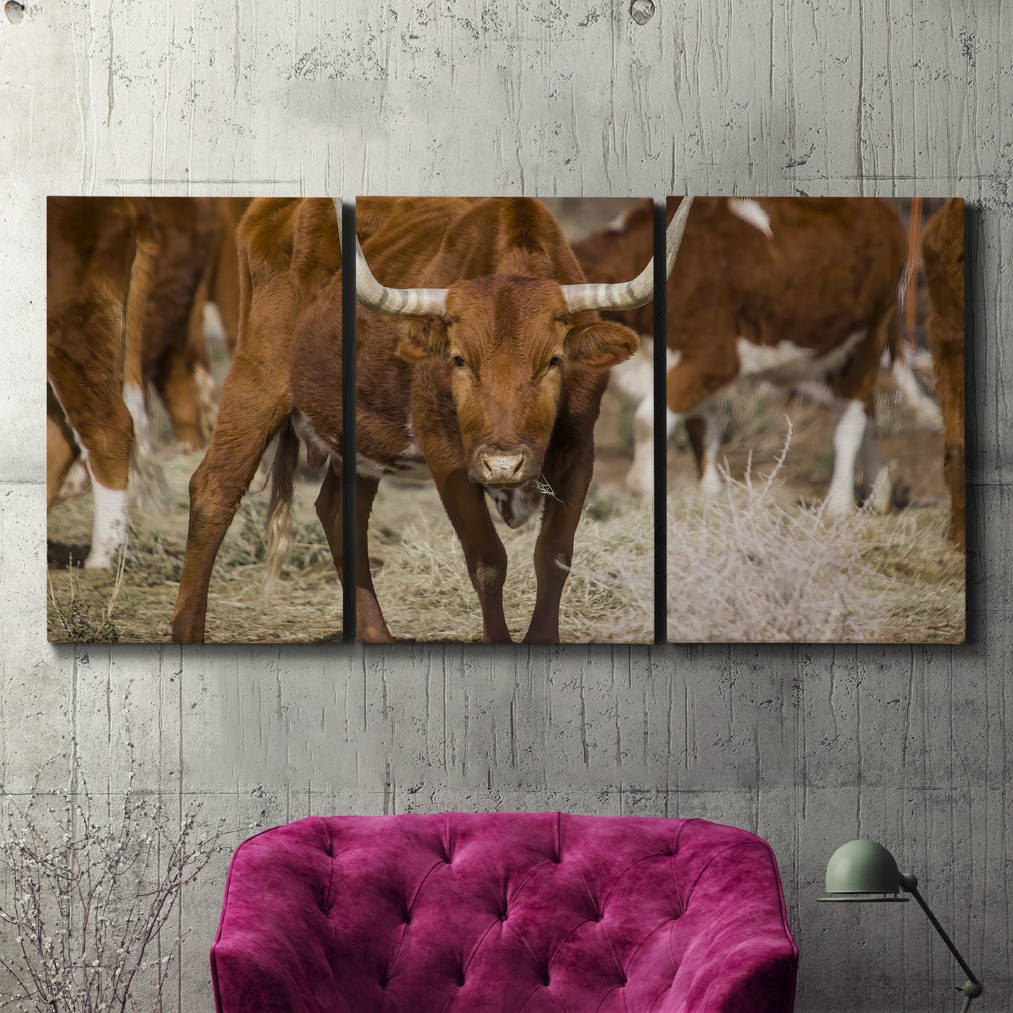 Three-panel canvas wall art featuring longhorn cattle standing together, displayed in a living room above a suede accent chair.