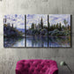 Three-panel canvas wall art featuring quiet river bend near village, displayed in a living room above a suede accent chair.