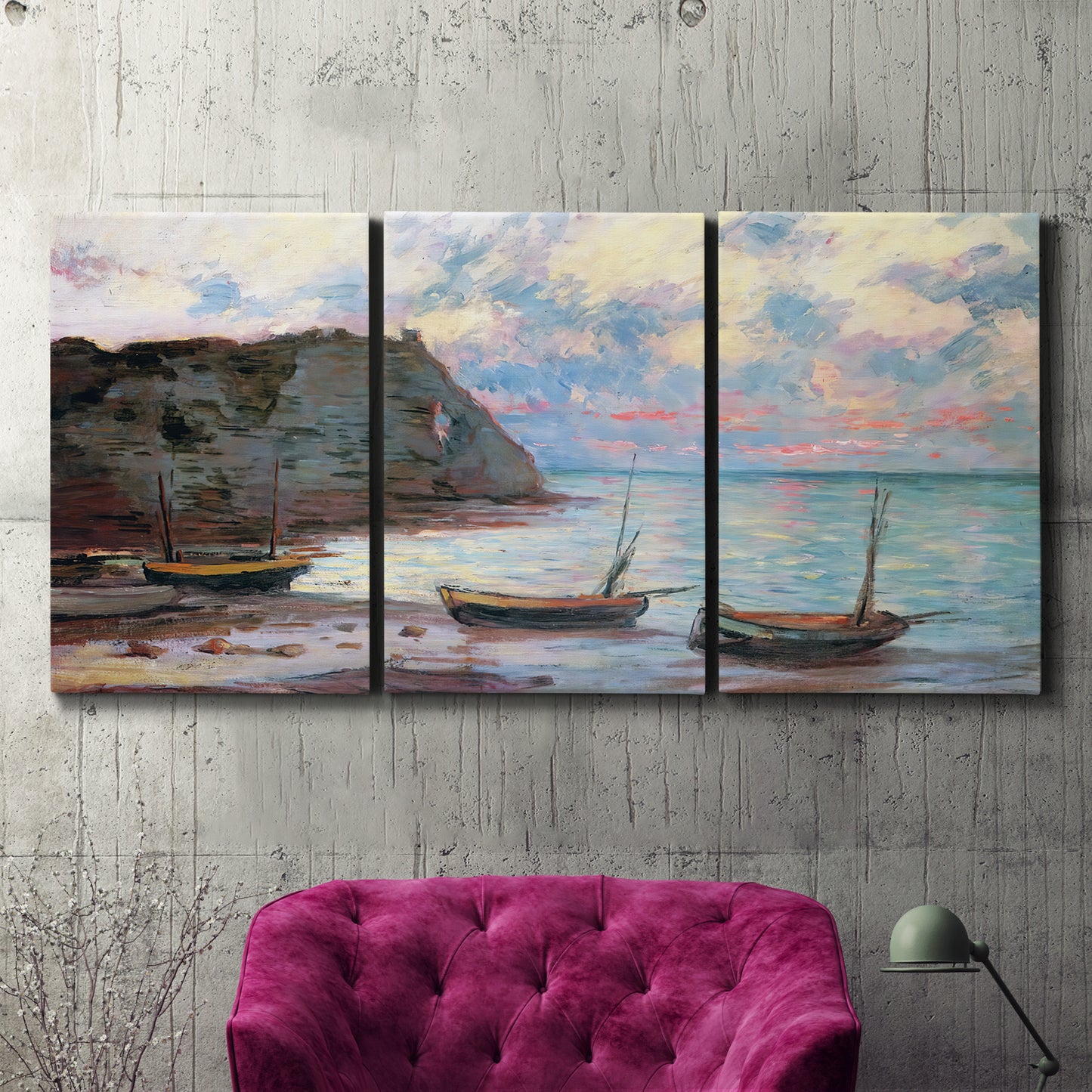 Three-panel canvas wall art featuring golden coastal sunset with cliffs, displayed in a living room above a suede accent chair.