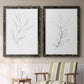 Set of two black barnwood framed canvas prints depicting two minimalist botanical line drawings featuring single continuous-line leafy branches above a sideboard in a cozy sitting room.