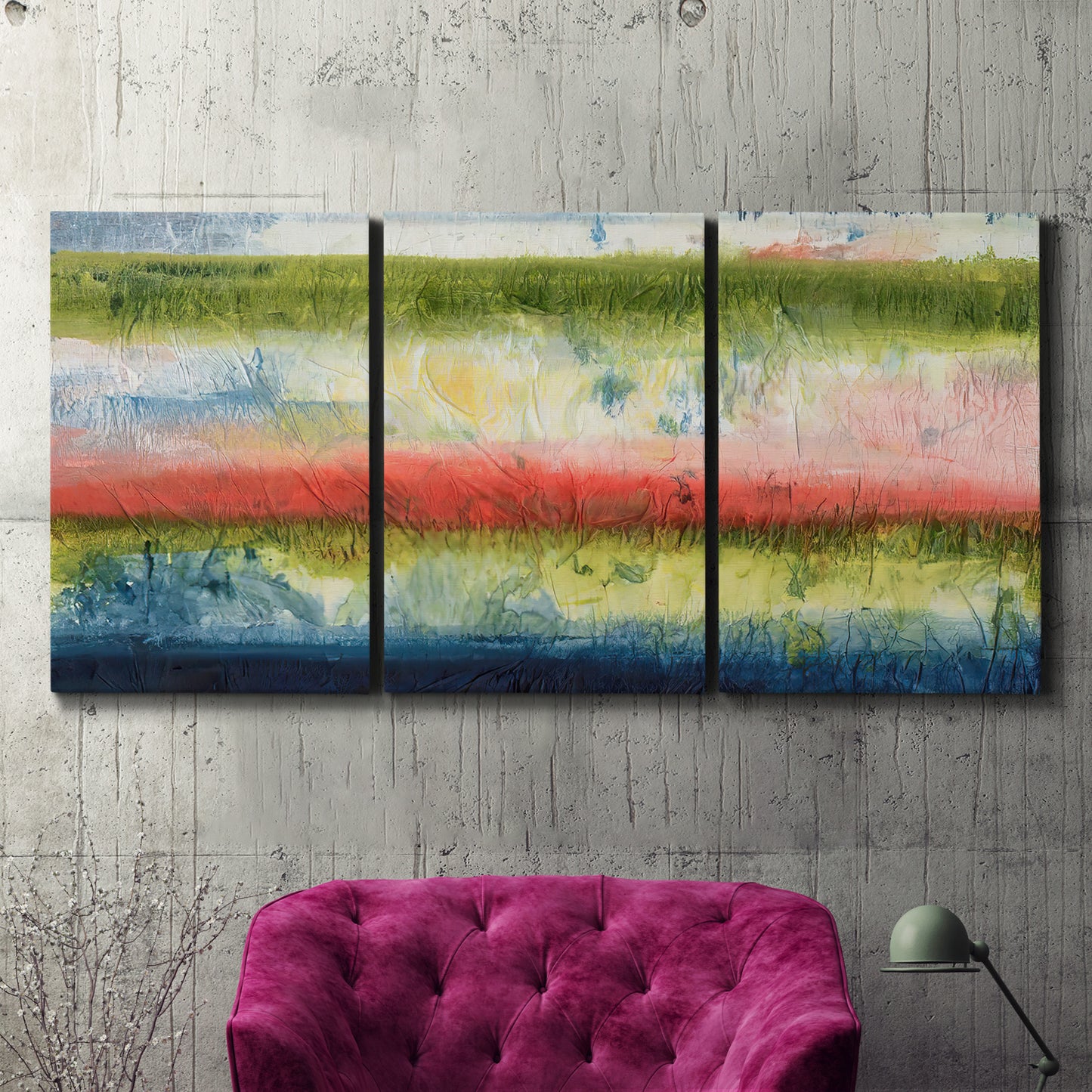 Three-panel canvas wall art featuring layered abstract color banding, displayed in a living room above a suede accent chair.