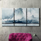 Three-panel canvas wall art featuring abstract rainstorm watercolor, displayed in a living room above a suede accent chair.