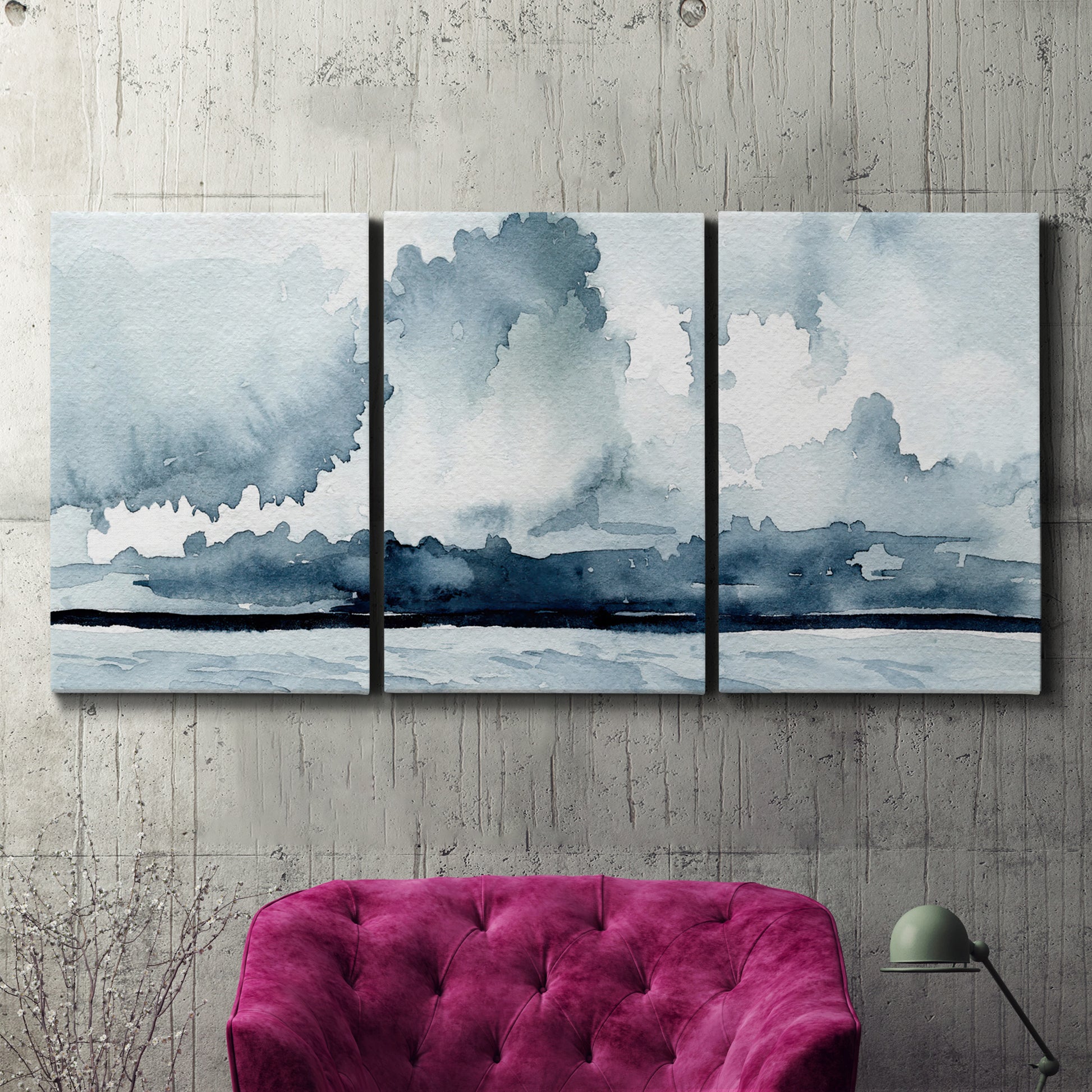 Three-panel canvas wall art featuring abstract rainstorm watercolor, displayed in a living room above a suede accent chair.