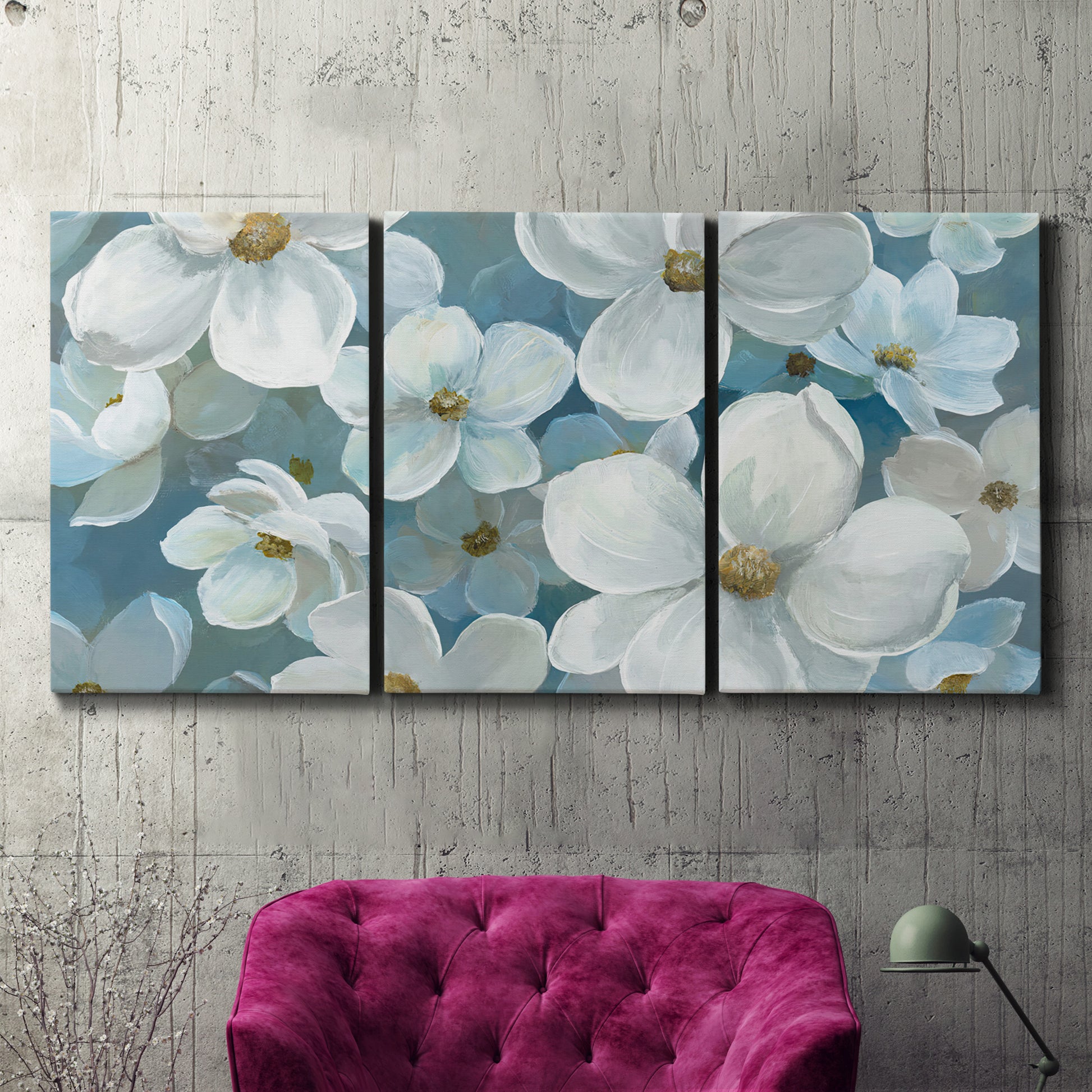 Three-panel canvas wall art featuring soft white floral abstraction, displayed in a living room above a suede accent chair.