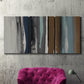 Three-panel canvas wall art featuring layered abstract amusement park tones, displayed in a living room above a suede accent chair.