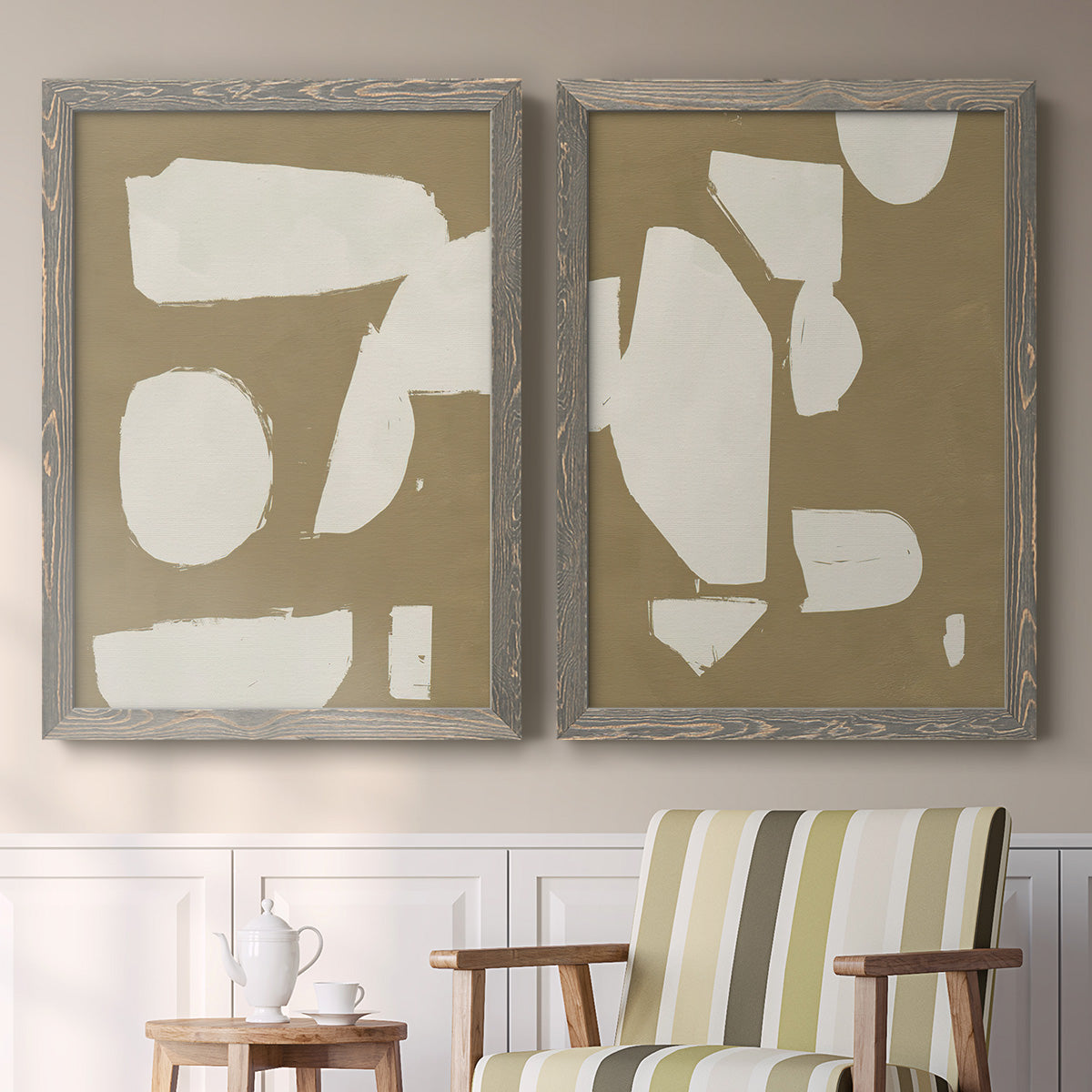 Set of two gray barnwood framed canvas prints depicting two bold minimalist shape abstracts featuring irregular white cutout-like shapes on taupe grounds above a sideboard in a cozy sitting room.