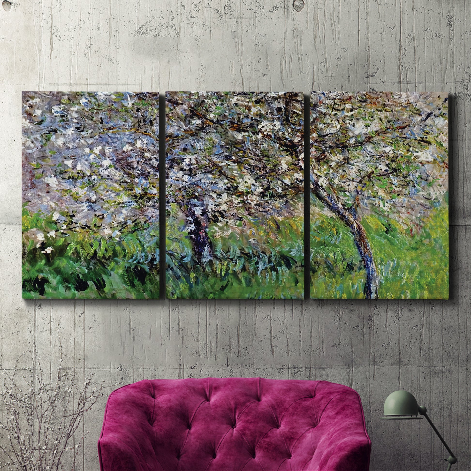 Three-panel canvas wall art featuring apple trees blooming beside water, displayed in a living room above a suede accent chair.