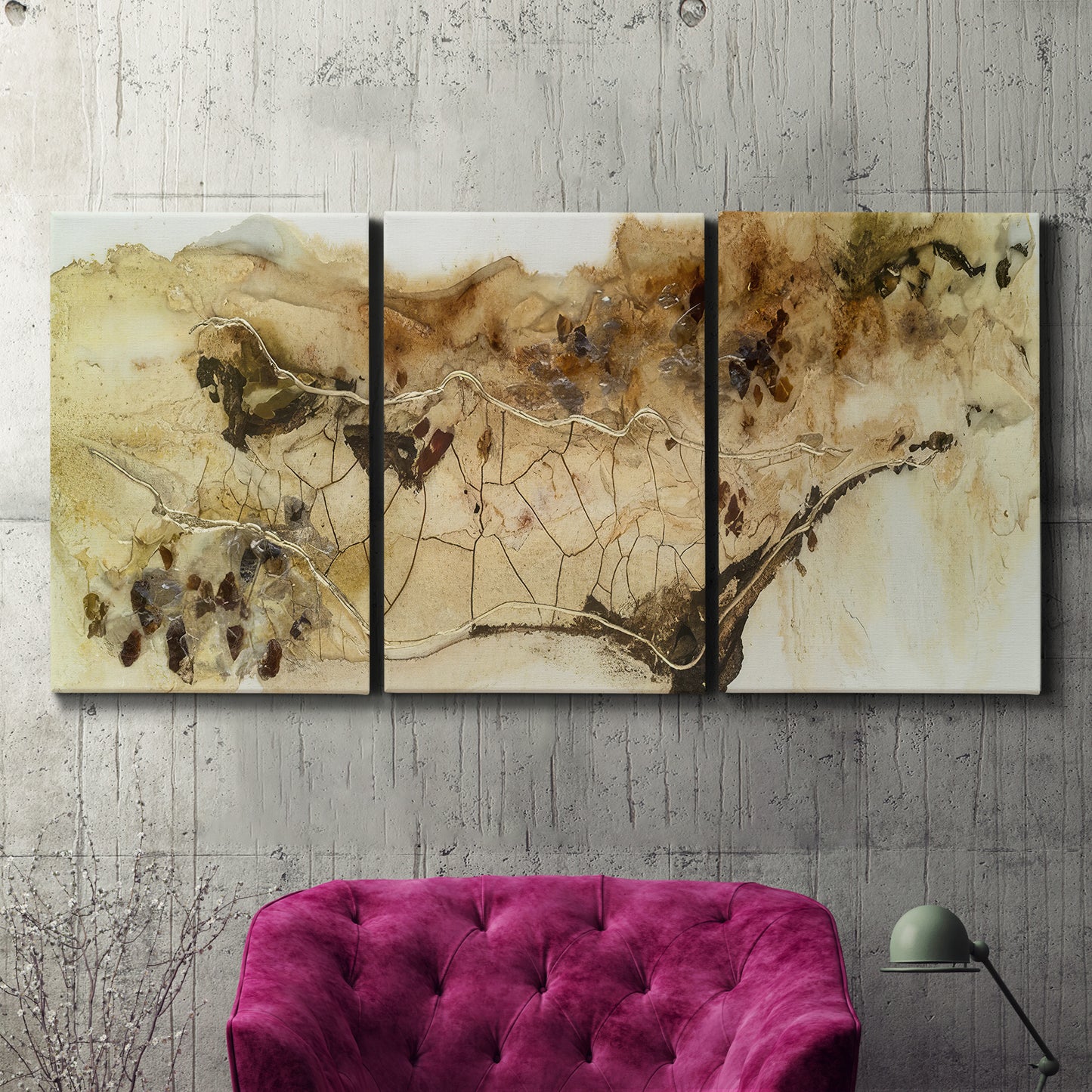 Three-panel canvas wall art featuring muted abstract with metallic gold accents, displayed in a living room above a suede accent chair.