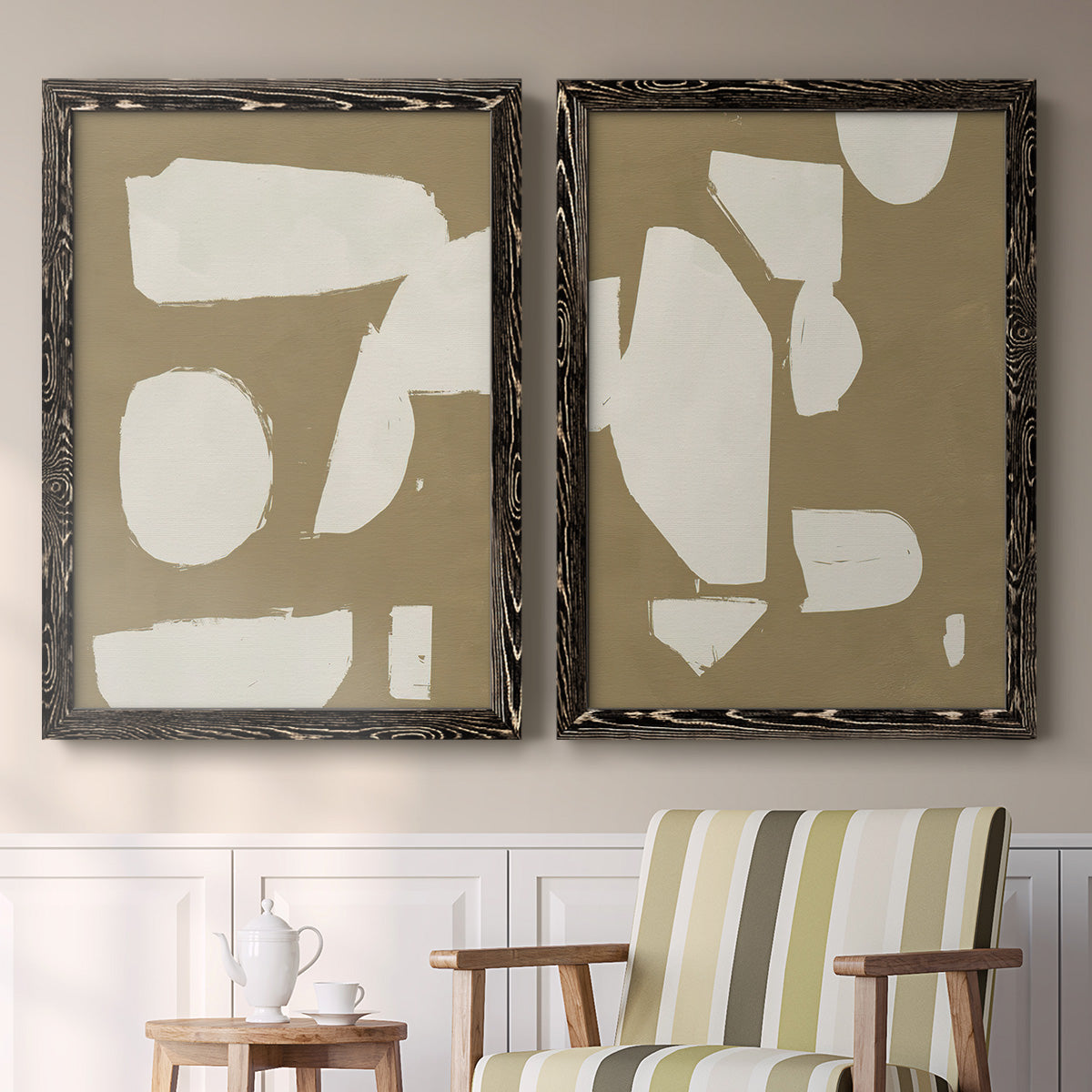 Set of two black barnwood framed canvas prints depicting two bold minimalist shape abstracts featuring irregular white cutout-like shapes on taupe grounds above a sideboard in a cozy sitting room.