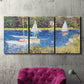 Three-panel canvas wall art featuring river scene with reflections, displayed in a living room above a suede accent chair.