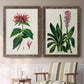 Set of two walnut barnwood framed canvas prints depicting two antique botanical plate illustrations featuring colorful flowering plant specimens above a sideboard in a cozy sitting room.
