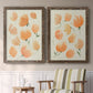 Set of two walnut barnwood framed canvas prints depicting two airy watercolor floral paintings featuring loose peach-orange tulip-like blossoms above a sideboard in a cozy sitting room.