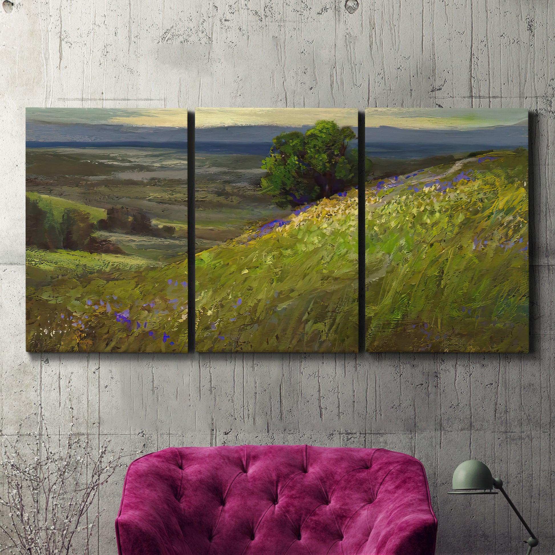 Three-panel canvas wall art featuring winding path through rolling hills, displayed in a living room above a suede accent chair.