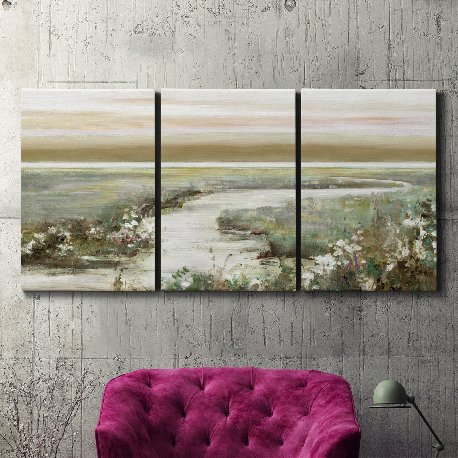 Three-panel canvas wall art featuring pastoral fields under soft sunrise, displayed in a living room above a suede accent chair.