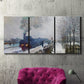 Three-panel canvas wall art featuring steam train in snowy landscape, displayed in a living room above a suede accent chair.