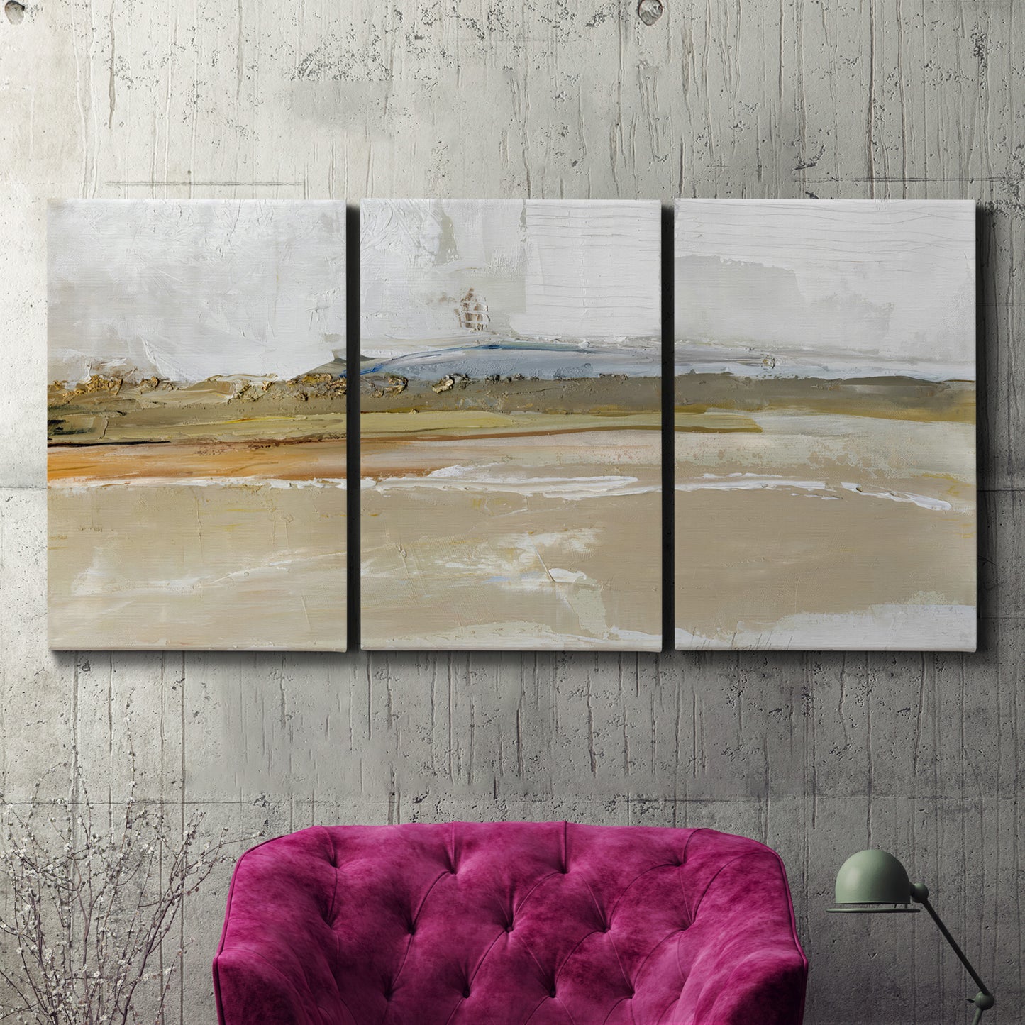 Three-panel canvas wall art featuring golden hour light over landscape, displayed in a living room above a suede accent chair.