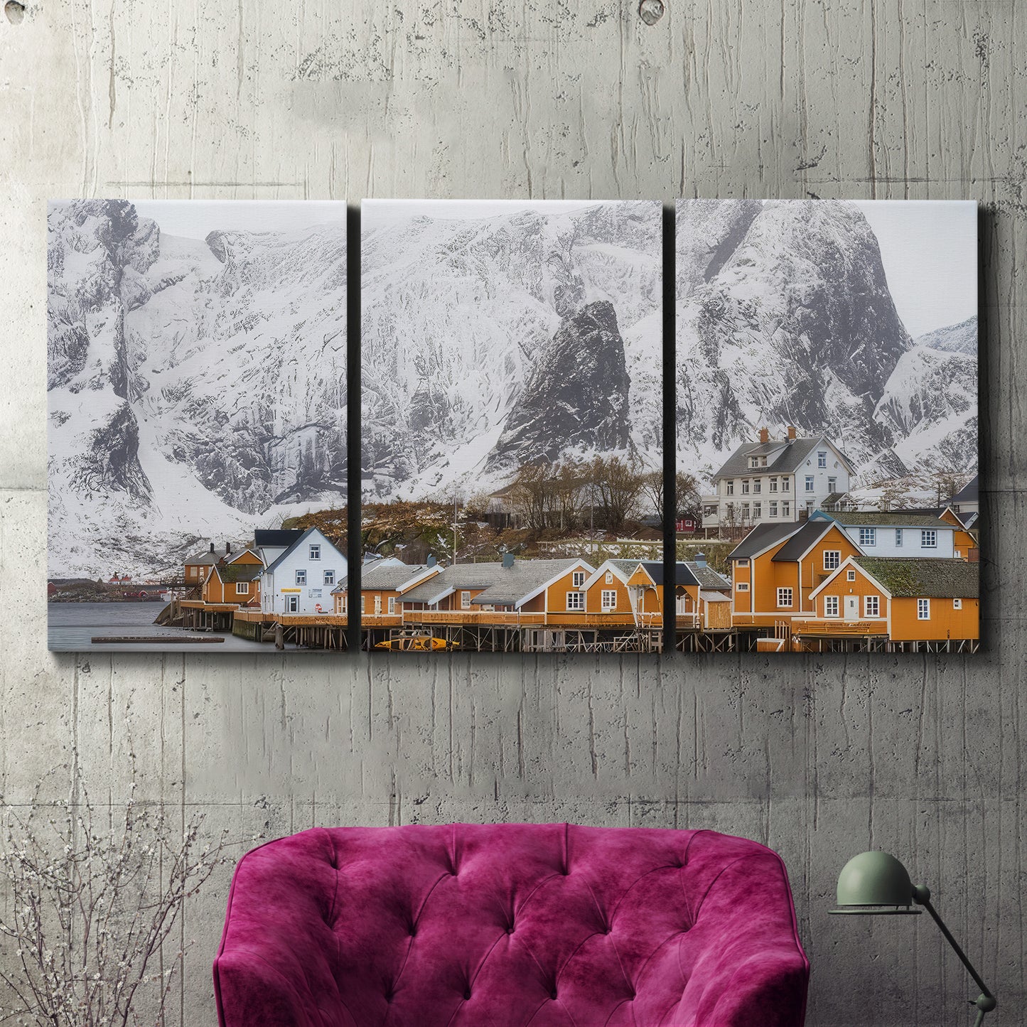 Three-panel canvas wall art featuring winter village street photography, displayed in a living room above a suede accent chair.