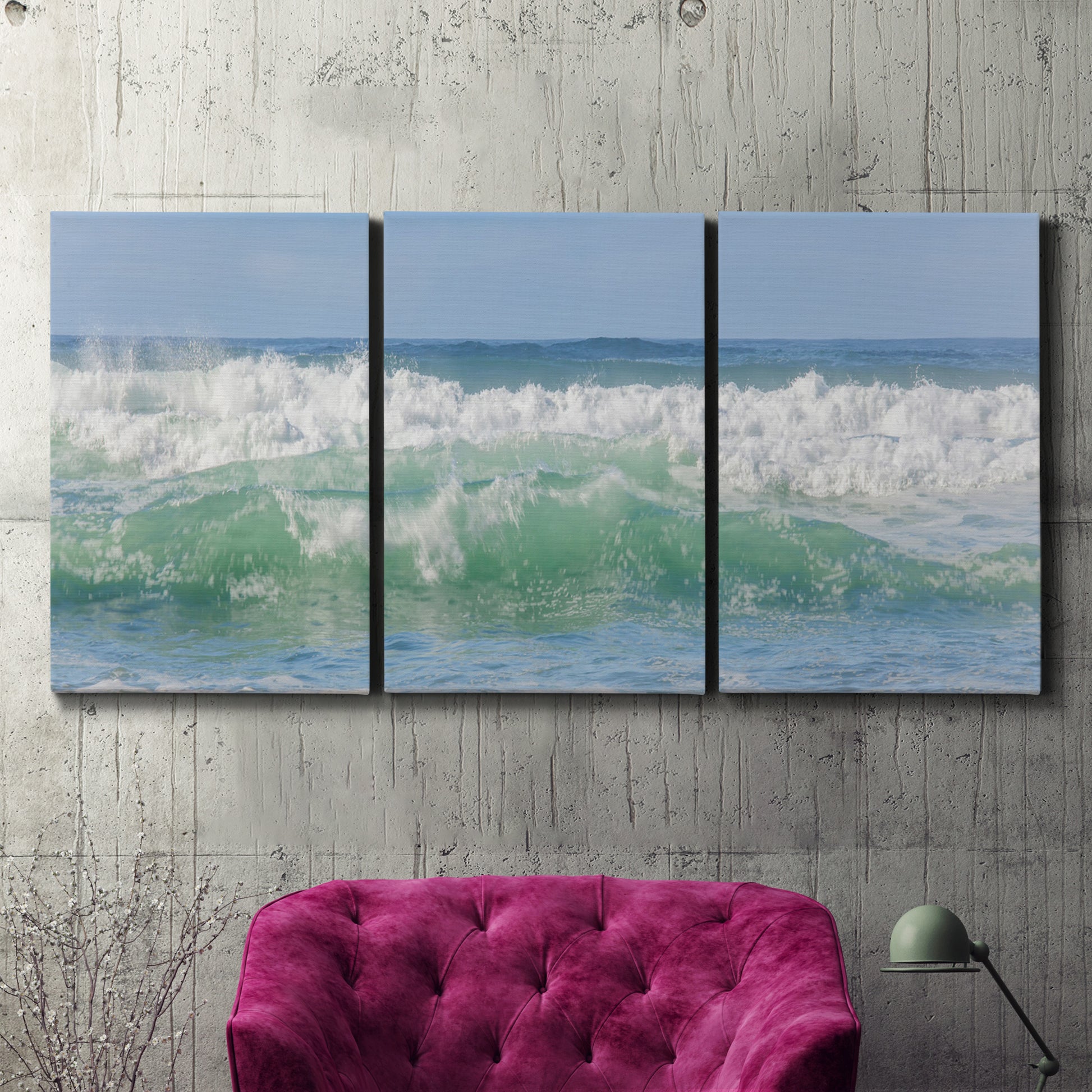 Three-panel canvas wall art featuring coastal waves breaking ashore, displayed in a living room above a suede accent chair.