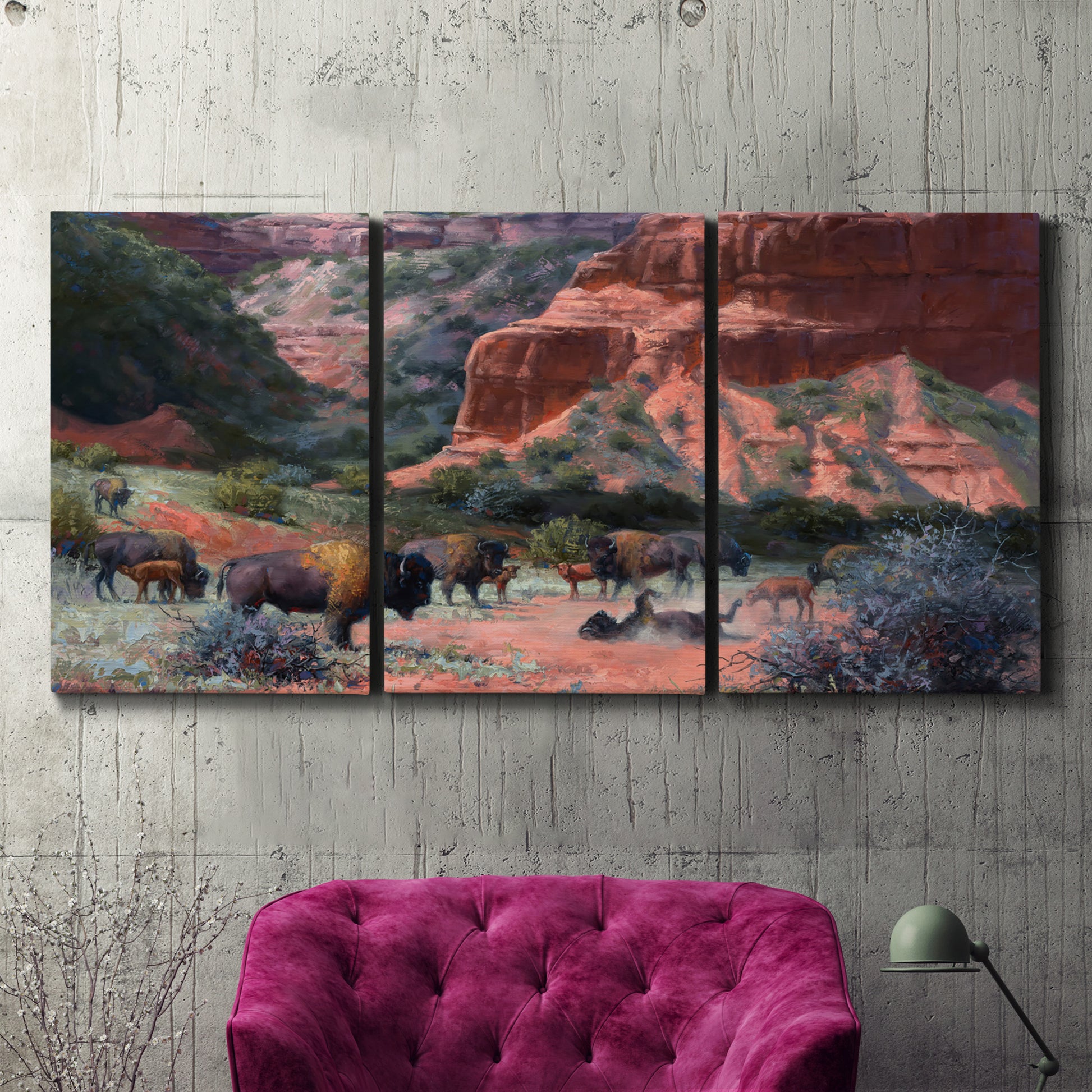 Three-panel canvas wall art featuring rugged canyon landscape with wildlife, displayed in a living room above a suede accent chair.