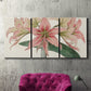 Three-panel canvas wall art featuring vintage styled amaryllis floral study, displayed in a living room above a suede accent chair.