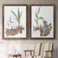 Set of two walnut barnwood framed canvas prints depicting two whimsical botanical animal illustrations featuring cats tucked among collections of potted houseplants above a sideboard in a cozy sitting room.
