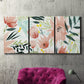 Three-panel canvas wall art featuring layered tropical plant collage, displayed in a living room above a suede accent chair.