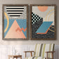 Set of two walnut barnwood framed canvas prints depicting two retro graphic abstracts featuring bold geometric Memphis-style patterns above a sideboard in a cozy sitting room.