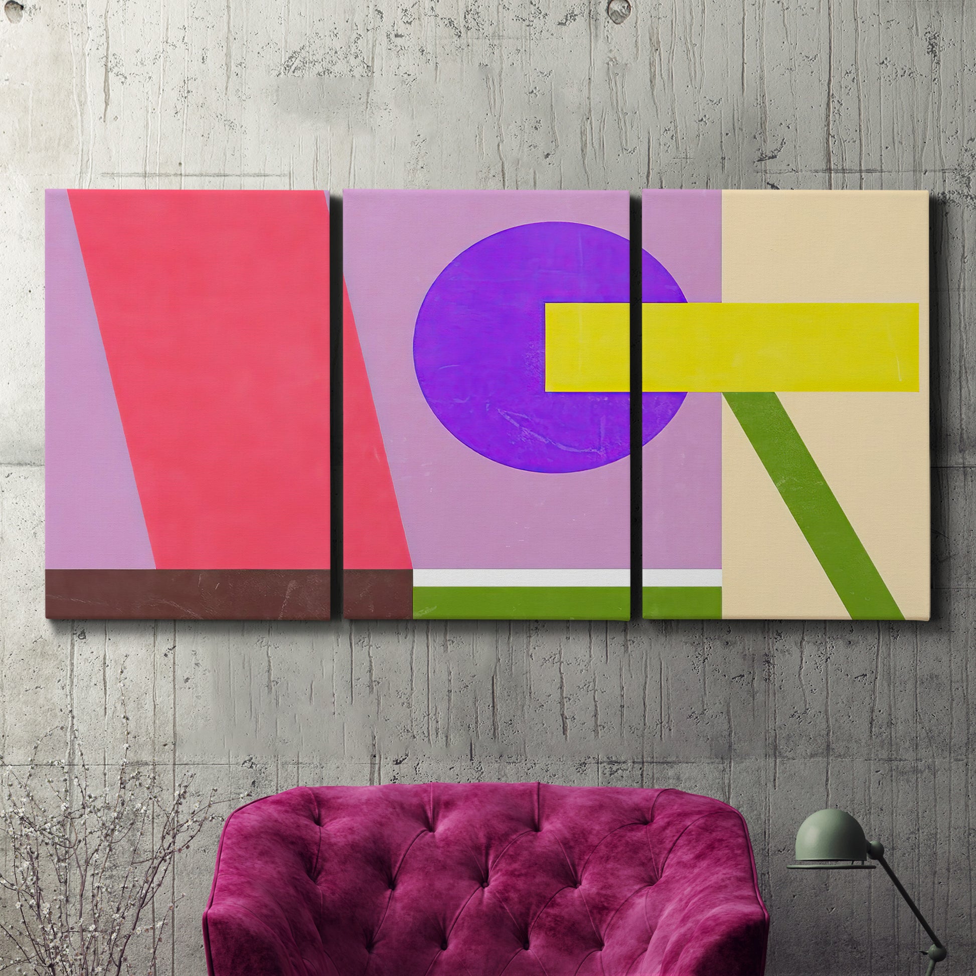 Three-panel canvas wall art featuring bold geometric color abstraction, displayed in a living room above a suede accent chair.