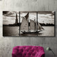 Three-panel canvas wall art featuring historic sailing ships photograph, displayed in a living room above a suede accent chair.