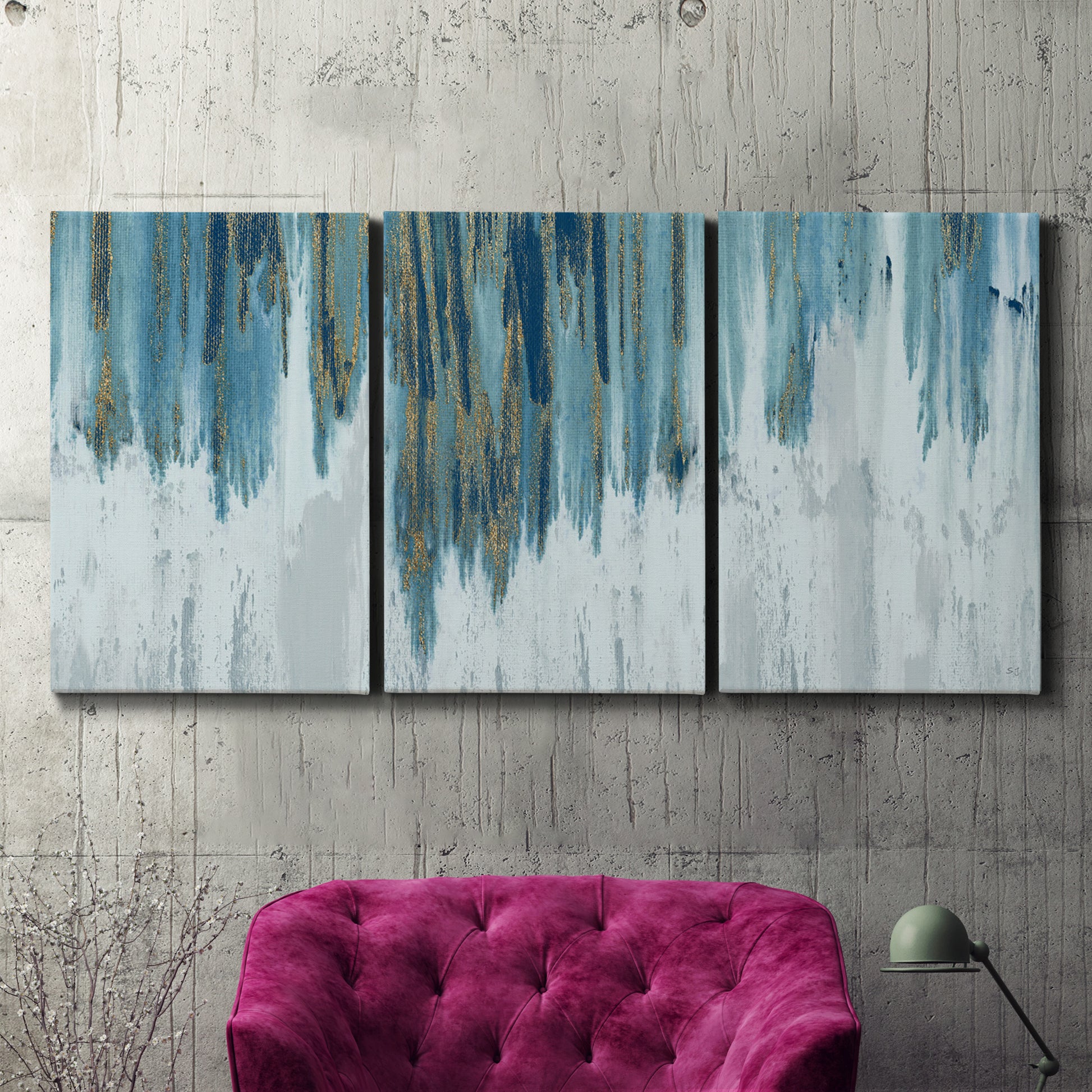Three-panel canvas wall art featuring wide pastoral valley landscape, displayed in a living room above a suede accent chair.
