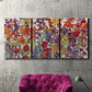 Three-panel canvas wall art featuring colorful floral arrangement, displayed in a living room above a suede accent chair.