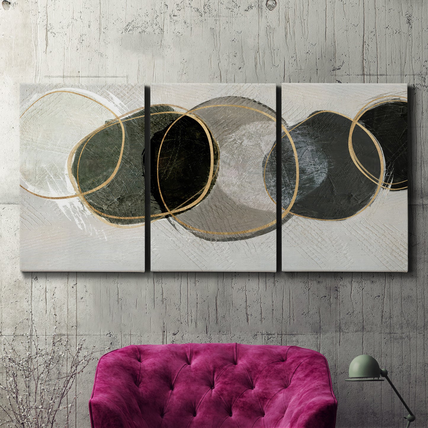 Three-panel canvas wall art featuring smooth abstract river stone forms, displayed in a living room above a suede accent chair.