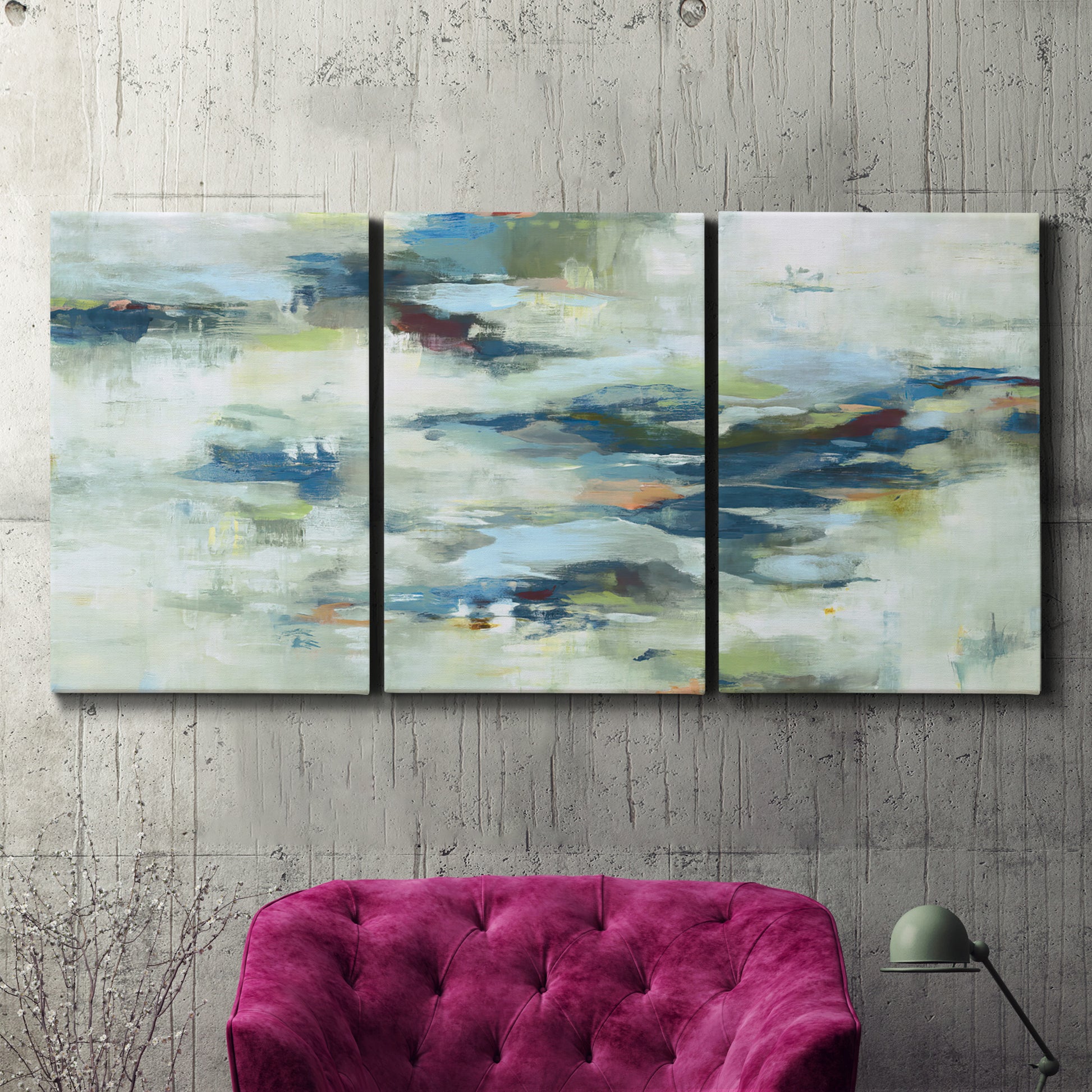 Three-panel canvas wall art featuring dreamlike abstract drifting motion, displayed in a living room above a suede accent chair.